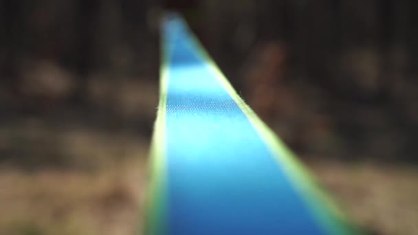 Hombre saltando y haciendo trucos en slackline en el bosque en cámara lenta — Vídeos de Stock