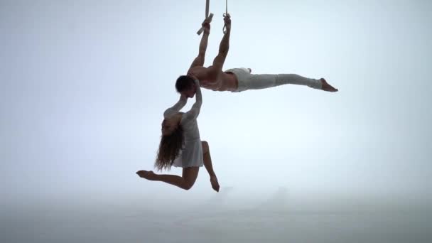 Aerial straps duo wearing white costume on white background doing performance in slow motion. Concept of desire, attraction and relationship — Stock Video