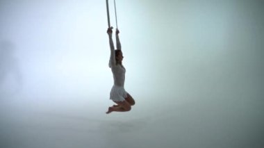 Beyaz arka planda beyaz kostüm giyen hava kayışlı ikili performans sergiliyor. Romantik çift kavramı 