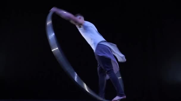 Артист цирка демонстрирует концентрацию и равновесие во время вращения на велосипедном колесе — стоковое видео