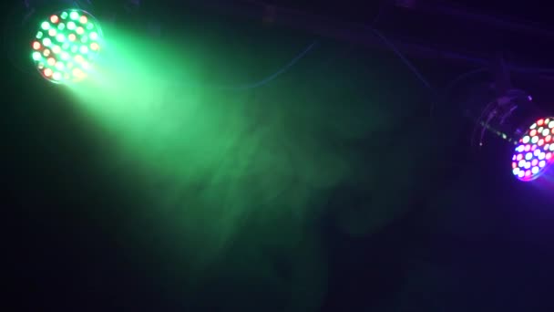 Vigas e raios de luz de holofotes através da fumaça no palco no clube em câmera lenta — Vídeo de Stock