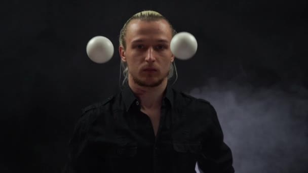 Muž v černém žongluje s bílými koulemi. Koncentrace, schopnost, rychlost, reakce — Stock video