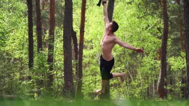 Man gör kalisthenics i den gröna parken. Friska natur och miljö — Stockvideo