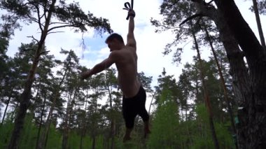 Sirk sanatçısı yeşil parkta yavaş çekimde jimnastik yapıyor. 