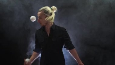 Siyah bir jonglör ve beyaz toplar takan bir adam. Yönetim, kontrol ve başarı