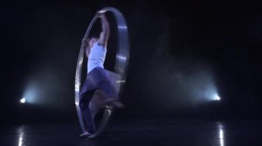 Sirk sanatçısı bir Cyr çarkında dönerken konsantrasyon ve denge gösteriyor