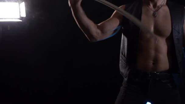 Muscular Man jugando con espada larga aislada sobre fondo negro — Vídeos de Stock
