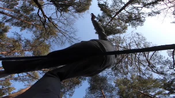 Чоловік стрибає і робить трюки на слабкій лінії в лісі в повільному русі — стокове відео