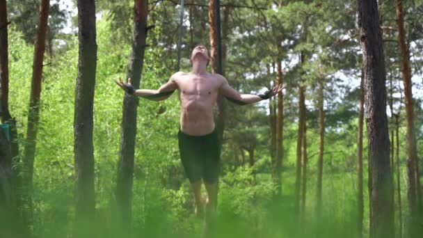 Circo artista fare calistenics nel parco verde con cinghie aeree rallentatore — Video Stock