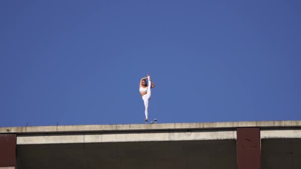 Wanita fleksibel menjaga keseimbangan dengan satu kaki di tepi bangunan yang sedang dibangun. Konsep risiko, keberanian dan kesempatan — Stok Video