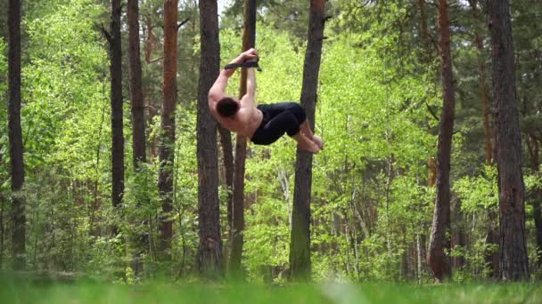 Circo artista fare calistenics nel parco verde con cinghie aeree rallentatore — Video Stock