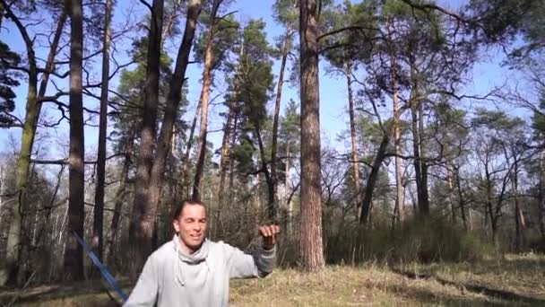 Man springen en doen trucs op slackline in het bos in slow motion — Stockvideo