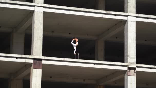 Flexibel kvinnlig cirkus Artist håller balansen till fots i den övergivna byggnaden. Utpressning och jämviktskoncept — Stockvideo