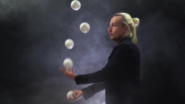 Man wearing a black juggling with white balls. Management, control and success — Stock Video