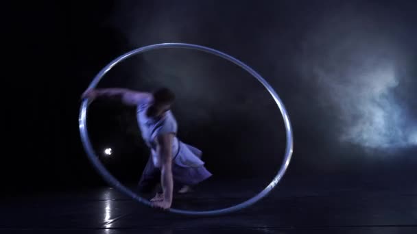 Артист цирка демонстрирует концентрацию и равновесие во время вращения на велосипедном колесе — стоковое видео