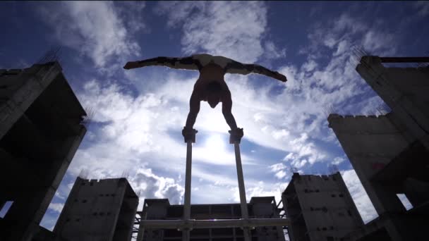 Cirque masculin flexible Artiste faisant main levée contre un paysage nuageux étonnant environnant par la contre-action industrielle. Individualité, créativité et concept de point de vue moderne — Video