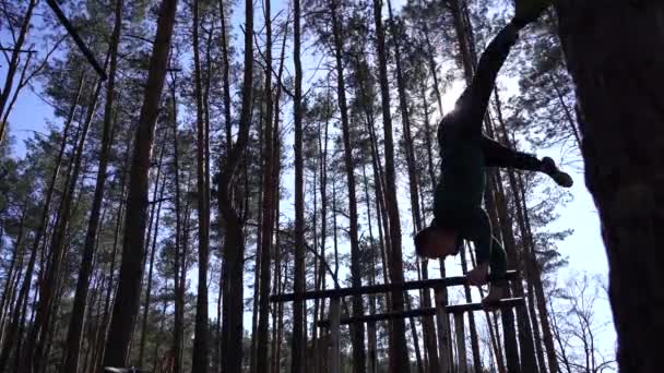 Człowiek uprawiający gimnastykę na równoległych barach w lesie. Zdrowy styl życia — Wideo stockowe