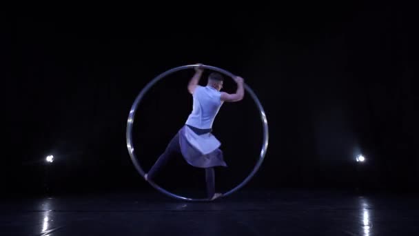 Akrobat otot jantan menunjukkan trik yang sulit untuk keseimbangan dan konsentrasi saat berputar pada roda Cyr — Stok Video