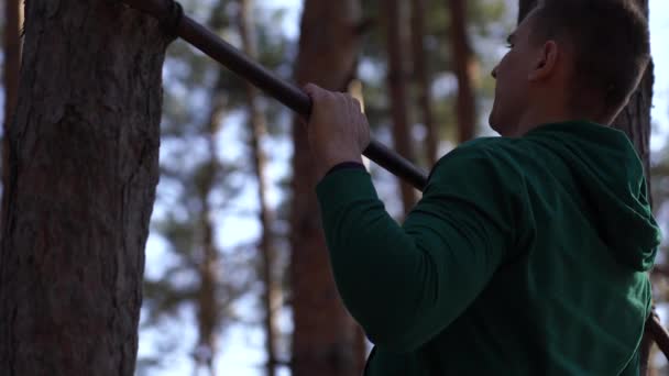 Člověk cvičí na vodorovné tyči v lese. Zdravý životní styl — Stock video