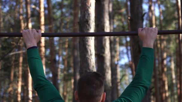 Člověk cvičí na vodorovné tyči v lese. Zdravý životní styl — Stock video