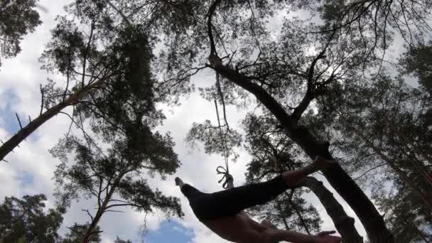 Hombre haciendo calistenia en el parque verde con TRX o correas aéreas. Vida sana y bienestar — Vídeo de stock