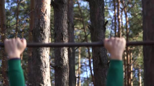 Uomo che lavora sulla barra orizzontale nella foresta. Stile di vita sano — Video Stock