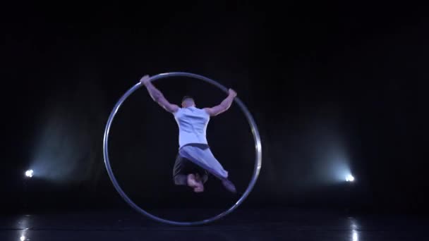 Cyr Wheel performer montre des tours sur une scène noire avec de la fumée — Video