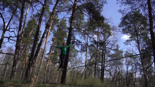 사람은 숲 속의 빗방울 위를 걸을 수있는 균형을 유지 한다 — 비디오