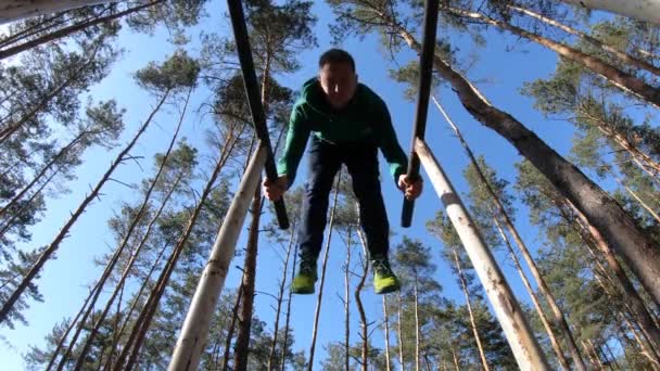 Чоловік займається гімнастикою на паралельних барах у лісі. Здоровий спосіб життя — стокове відео