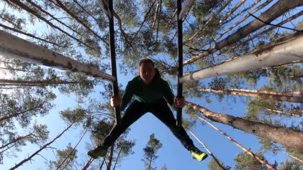 Mannen gör gymnastik på parallella barer i skogen. En hälsosam livsstil — Stockvideo