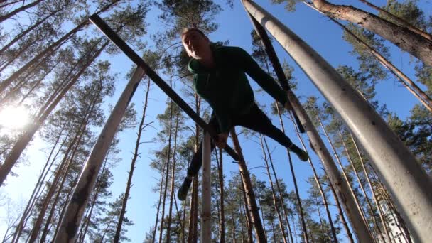 Mannen gör gymnastik på parallella barer i skogen. En hälsosam livsstil — Stockvideo