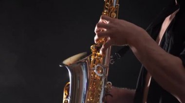 Siyah arkaplanda izole edilmiş saksafonda çalan ellerin yakınlaştırılması 