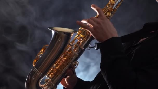 Närbild av händer spelar på saxofon isolerad på rökt bakgrund — Stockvideo