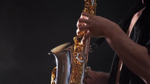 Close-up van de handen spelen op saxofoon geïsoleerd op zwarte achtergrond — Stockvideo