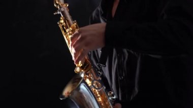 Siyah arkaplanda izole edilmiş saksafonda çalan ellerin yakınlaştırılması 