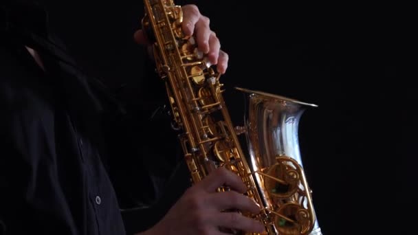 Close-up van de handen spelen op saxofoon geïsoleerd op zwarte achtergrond — Stockvideo