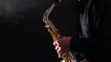 Siyah arkaplanda izole edilmiş saksafonda çalan ellerin yakınlaştırılması 