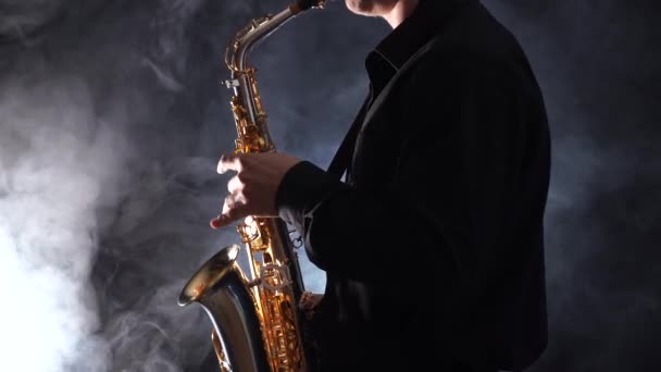Närbild av händer spelar på saxofon isolerad på rökt bakgrund — Stockvideo
