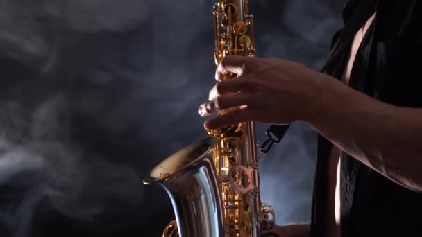 Sluiten van handen spelen op saxofoon geïsoleerd op gerookte achtergrond — Stockvideo