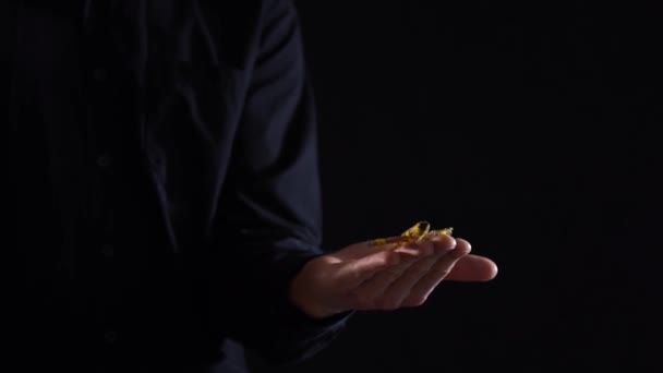 Close-up van handen controle magische pop op zijn hand opstijgen op zwarte achtergrond — Stockvideo