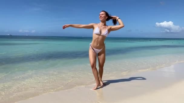 Szexi bikini test nő játékos a paradicsomi trópusi strandon szórakozás a szabadság tárt karokkal. Gyönyörű fit test lány az utazás nyaralás — Stock videók