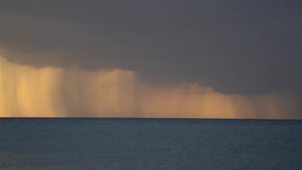 Καταιγίδα πάνω από τη θάλασσα κατά την ανατολή, πορτοκαλί χρώμα. Βαριά βροχή και σύννεφα πάνω από το νερό — Αρχείο Βίντεο