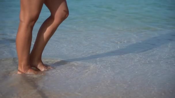 Donna sexy in bikini bianco passeggiando in spiaggia con acqua cristallina al rallentatore. concetto di viaggio, benessere e felicità — Video Stock