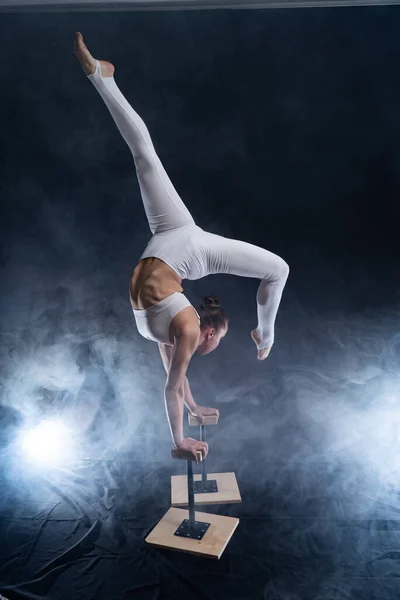 Artista de circo flexible - acróbata femenina haciendo soporte de mano en la espalda y fondo de fumador. Concepto de individualidad y creatividad — Foto de Stock