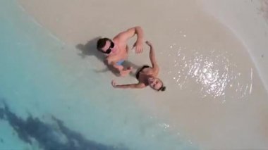 Tropik sahildeki mutlu çift İHA ile eğleniyor. Tatil, seyahat ve boş zaman kavramı 