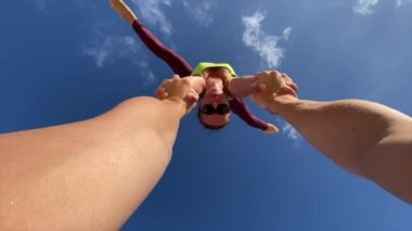 Bir kızla bir adam gökyüzü arka planında akrobasi numaraları yapıyor. Sağlıklı yaşam tarzı ve mutluluk kavramı.