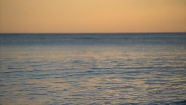Água do mar no crepúsculo durante o nascer do sol cor de laranja e azul. — Vídeo de Stock