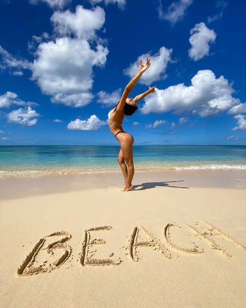 Sexy bikini mujer juguetona en la playa tropical paraíso con inscripción. Concepto de viajes y vacaciones — Foto de Stock