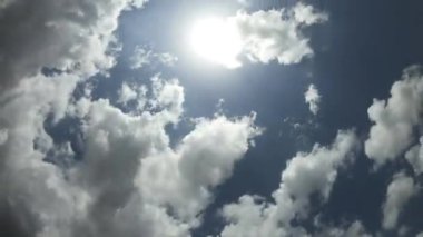 Mavi gökyüzünde hareket eden yuvarlanan kabarık bulutların zamanı