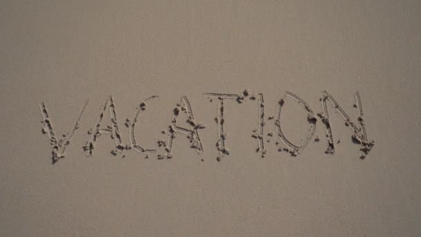 Διακοπές επιγραφή κύμα ξεπλένει μακριά στην αμμώδη παραλία του καλοκαιριού σε αργή κίνηση. Έννοια του τέλους των διακοπών — Αρχείο Βίντεο